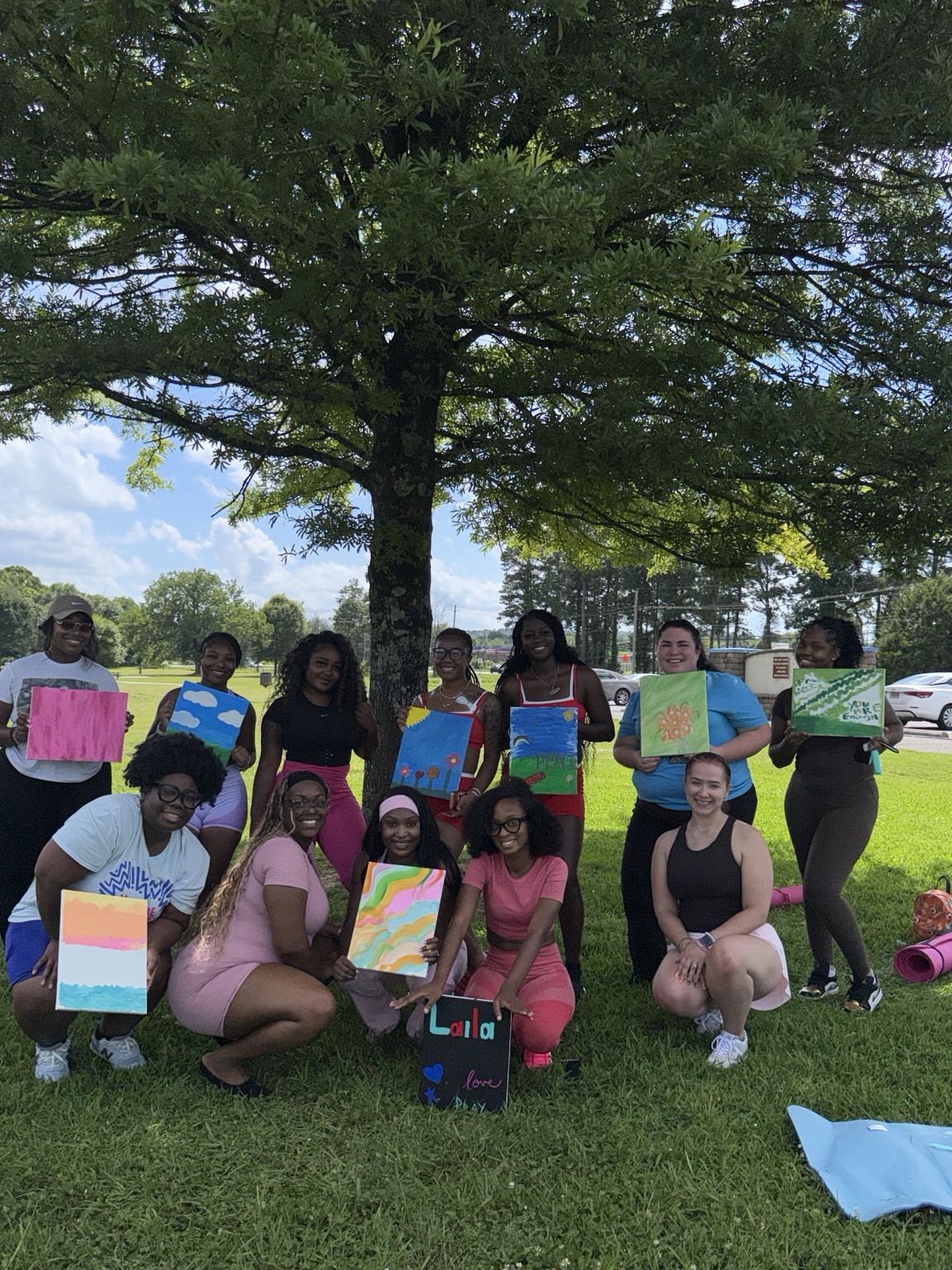 Participants showing their paintings at Love, Action, & Yoga
